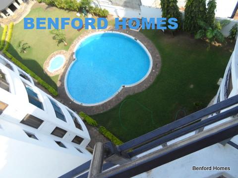 Aerial view of a kidney-shaped pool by a modern building.| Properties for renting Nyali