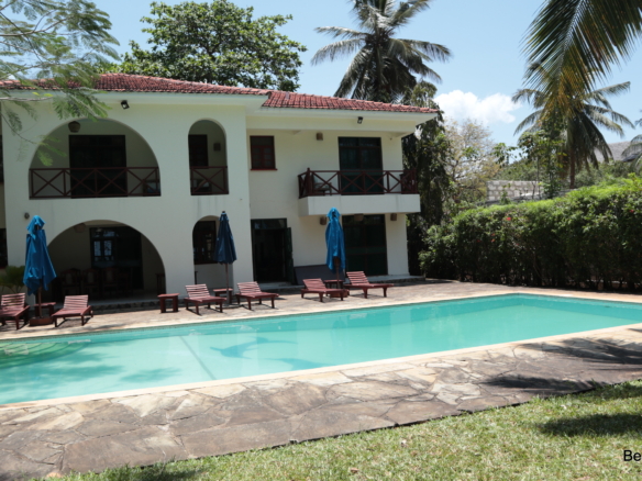Outdoor swimming pool with a garden and trees in a luxurious 4 bedroom villa| Benford Homes