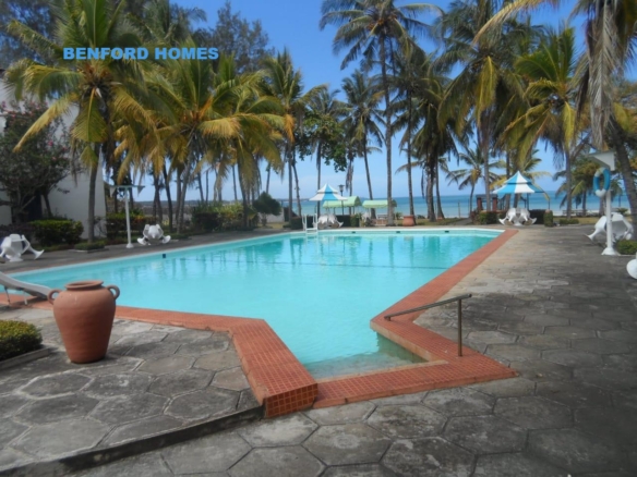 crystal-clear pool framed by graceful palm trees with the egde blending with the white sandy beaches| Benford Homes