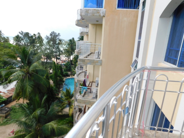 Balcony view of apartments with well trimmed trees and pool | Benford Apartments for rent in Nyali